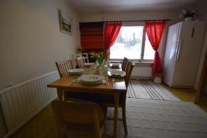 a kitchen with a wooden table with chairs and a refrigerator at Traditional House Rovaniemi in Rovaniemi