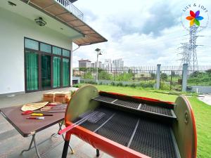 a table and chairs on a patio with a garden at 40P, Subang Villa with Pool/BBQ/Karaoke/Meeting in Subang Jaya