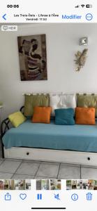 a blue couch with colorful pillows in a room at La Perle des Anses in Les Trois-Îlets
