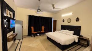 a bedroom with a bed and a flat screen tv at Orbit Royal in Islamabad