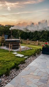 una pasarela de piedra que conduce a un edificio en un campo en Owczarnia Tatry en Bukowina Tatrzańska