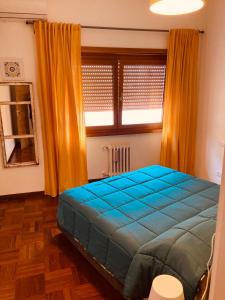 Un dormitorio con una cama azul y una ventana en Domus Cornelia, en Roma