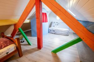 an attic room with a bed and wooden stairs at L'Inattendue - Villa pour 8pers. in Pocé-sur-Cisse