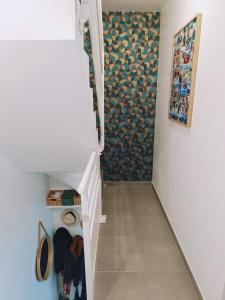 a hallway with a staircase with a shower and a wall with a painting at Charmante maison de ville in Lyon