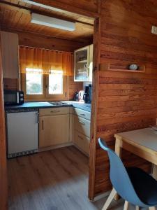 - une cuisine dans une cabane en rondins avec une table et une chaise dans l'établissement Ferienhaus Keller, à Freyung