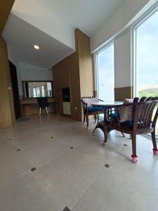 鵝鑾的住宿－迦那會館，客房设有桌椅和大窗户。