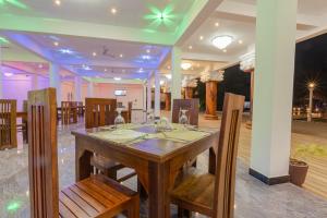 una sala da pranzo con tavolo e sedie in legno di Elysia Sigiriya Hotel a Dambulla