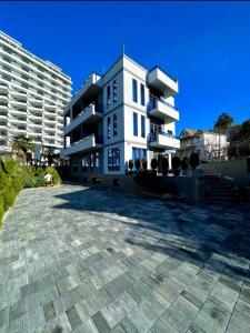 a large white building with a parking lot at Queen Tamar in Batumi