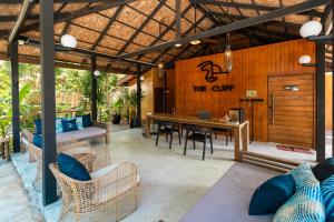 an outdoor living room with a table and chairs at The Cliff Lipe in Ko Lipe