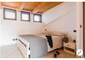 a bedroom with a bed in a room with windows at Il Conero Bilocale con posto auto privato in Osimo