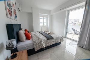 1 dormitorio con cama y ventana grande en Drapetsona Modern Living (DRAP_C2), en Pireo