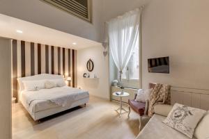 1 dormitorio con 1 cama, 1 silla y 1 sofá en Trevi Miracle Suite, en Roma