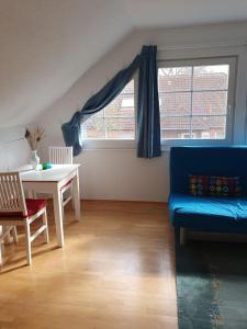 ein Wohnzimmer mit einem blauen Sofa und einem Tisch in der Unterkunft Gemütliche Ferienwohnung in Potsdam