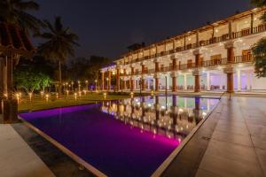 丹不拉Elysia Sigiriya Hotel的夜晚带有游泳池的建筑物