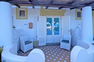 - une chambre avec deux chaises et une porte dans l'établissement Dependance La Caletta, à Panarea