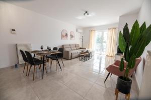 sala de estar con mesa, sillas y sofá en Drapetsona Modern Living (DRAP_C2), en Pireo