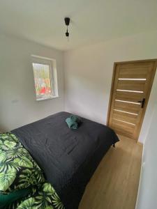 a bedroom with a bed and a wooden door at Apartament Guziczek2 in Nowy Targ