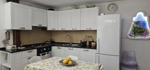 a kitchen with a table and a white refrigerator at LA Giulia in Capri