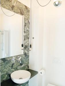 bagno con lavandino bianco e specchio di Casa verde in De Rosa ad Acquaviva delle Fonti