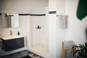 a white bathroom with a shower and a sink at Ferienwohnung im Allgäu in Durach
