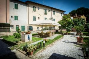 a garden with a table and an umbrella in front of a building at Locanda dei Fiori in Pistoia