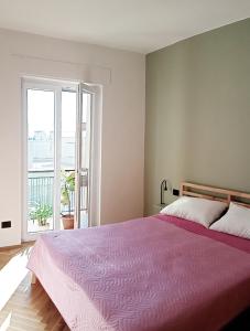 una camera con letto rosa e ampia finestra di Casa verde in De Rosa ad Acquaviva delle Fonti