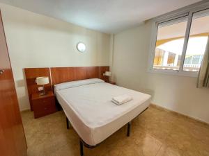 sypialnia z łóżkiem i oknem w obiekcie Apartamentos Gardenias 3000 w mieście Alcossebre