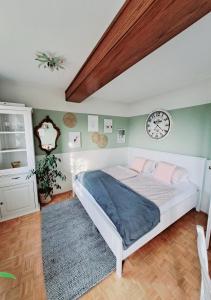 a bedroom with a bed and a clock on the wall at Ferienwohnung "Glücksplatzerl" in Mondsee
