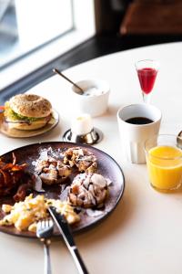 Stenungsbaden Yacht Club في ستينانغسوند: طاولة مع طبق من طعام الإفطار ومشروب