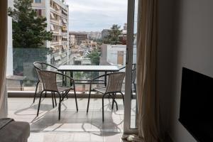 balcón con mesa, sillas y vistas en Drapetsona Modern Living (DRAP_C2), en Pireo