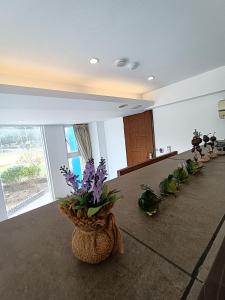 una habitación con una fila de jarrones con flores en el suelo en 迦那會館, en Eluan