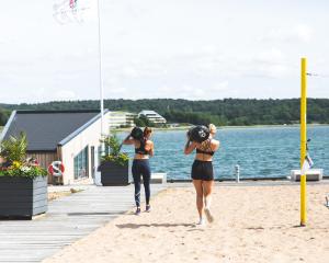 two women in bathing suits walking on the beach at Stenungsbaden Yacht Club in Stenungsund