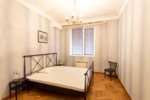 Schlafzimmer mit einem Bett und einem Fenster in der Unterkunft Suite Penthouse 55 in Tbilisi City