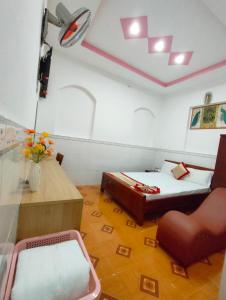 a small room with two beds and a chair at Hotel Thanh Vân in Thuan An