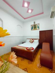 a bedroom with a bed and a chair in it at Hotel Thanh Vân in Thuan An