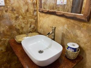La salle de bains est pourvue d'un lavabo blanc et d'un miroir. dans l'établissement Adventurevilla, à Kendwa