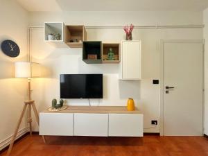 una sala de estar con TV en un armario blanco en Cozy & Budget Apartment near the Beach, en Domaso