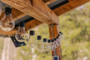 a bunch of wine glasses hanging from a beam at River house "Green butterfly" in Netretić