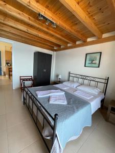 a large bed in a room with a wooden ceiling at Kimothoy in Armenistis