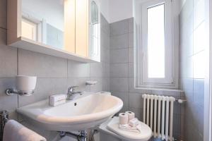 a white bathroom with a sink and a mirror at Casa Palma - Happy Rentals in Lugano