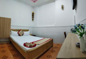 ein Schlafzimmer mit einem Bett und einer Vase aus Blumen in der Unterkunft Hotel Thanh Vân in Thuan An