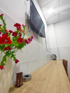 a vase with red flowers sitting on a table at Hotel Thanh Vân in Thuan An