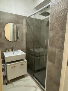 ein Bad mit einer Dusche, einem Waschbecken und einem Spiegel in der Unterkunft Sol Casa in Cosenza