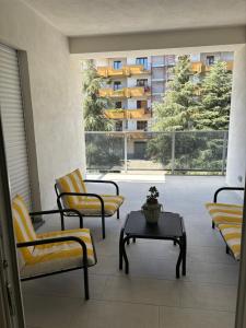 Zimmer mit Stühlen, einem Tisch und einem großen Fenster in der Unterkunft Sol Casa in Cosenza