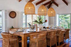 uma sala de jantar com uma grande mesa de madeira e cadeiras em Mountain View Villa em Cidade do Cabo