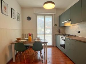 una cocina con mesa, sillas, mesa y mesa en Cozy & Budget Apartment near the Beach, en Domaso