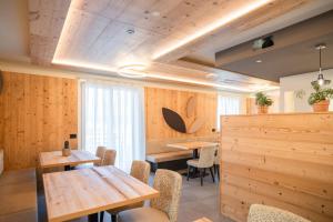 een restaurant met houten muren en tafels en stoelen bij B&B al Borgo in San Lorenzo in Banale