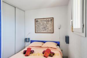 ein Schlafzimmer mit einem Bett mit roten Kissen darauf in der Unterkunft Croisette II, sea view and swimming pool in Sète
