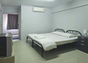 1 dormitorio con 1 cama y TV en Toucan Bed and Cafe, en Samutprakarn