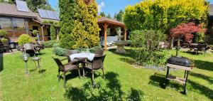 a backyard with a table and chairs and a grill at Eko Hotel Na Wierzynka & Park Pinokia in Wieliczka